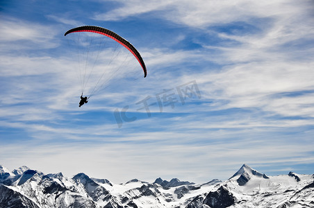 一鸟一伞摄影照片_冬季山脉和滑翔伞有山脉背景