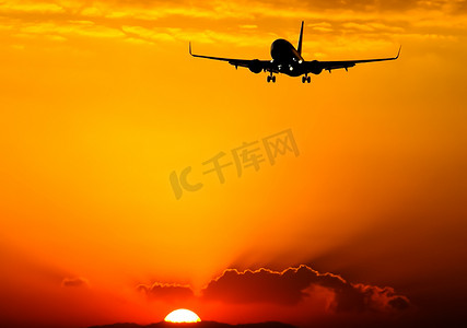 飞机夕阳摄影照片_一架客机在夕阳的背景下起飞。