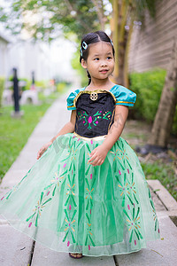站在公园里穿着公主裙的可爱微笑小女孩的画像