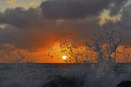 溅起的浪花摄影照片_夕阳下的浪花