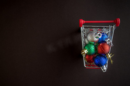 带有圣诞球玩具的杂货车，背景为深色简单。