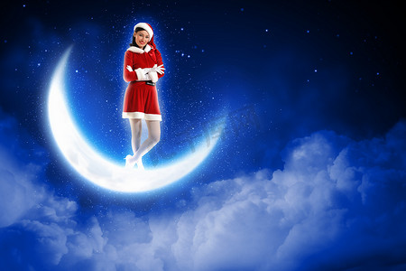 坐在月亮上的圣诞老人女孩的照片