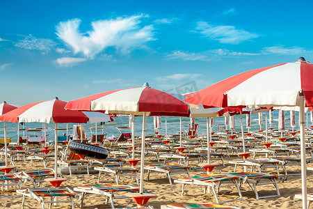 沙滩上的红色和白色遮阳伞和太阳伞