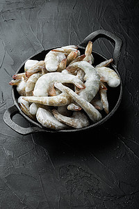 虎文字摄影照片_虎虾或亚洲虎虾的冷冻壳，铸铁煎锅，黑石背景，有文字复制空间