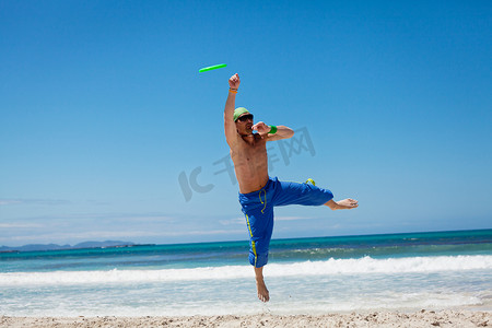 夏天在海滩上玩飞盘的迷人男人