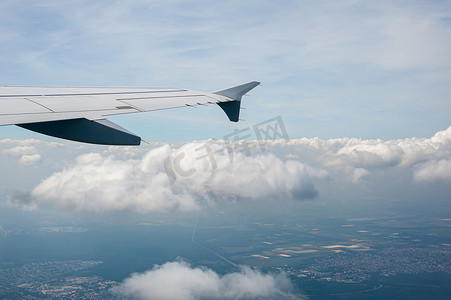 在高空多云的天空从机载飞机窗口查看。