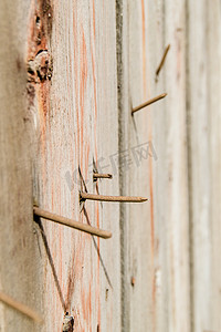 垂直拍摄，旧生锈钉子的特写，从深色旧木板上伸出，木材质地，复古色调表面