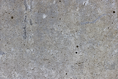 混凝土质感摄影照片_带有许多微小气泡的平坦灰色混凝土表面
