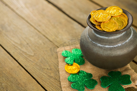 金币巧克力摄影照片_圣帕特里克节三叶草和装满巧克力金币的罐子