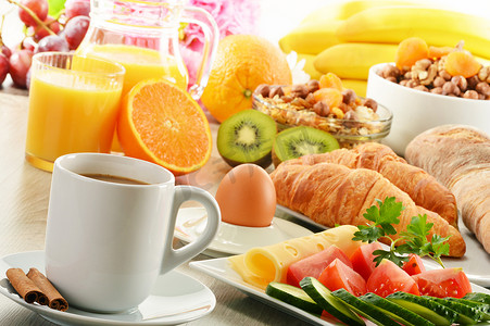 面包鸡蛋橙汁摄影照片_早餐用咖啡、橙汁、羊角面包、鸡蛋、蔬菜