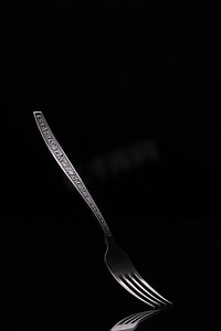 餐饮卡片摄影照片_在黑色背景上的旧钢叉。