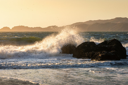 强风吹来的巨浪在太阳下抚摸着贝克海滩的大石头