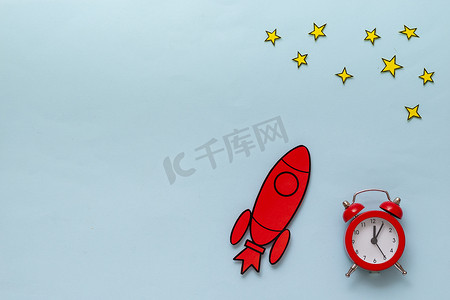 卡通火箭红色摄影照片_带闹钟和星星的红色卡通火箭