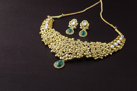 印度传统珠宝，深色背景中吊坠和耳环的特写