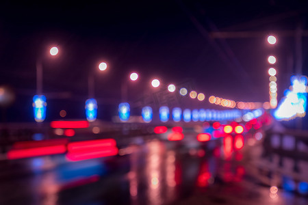 老年人起夜摄影照片_移动的汽车和灯笼的模糊灯光反射在夜城潮湿的沥青上。
