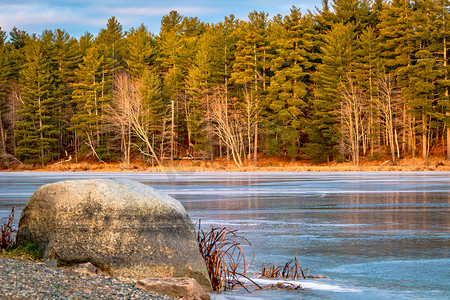 在一个结冰的湖的海滩的一块大石头