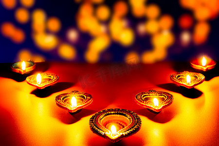 烟花点亮夜空摄影照片_印度节日排灯节，Diya 油灯在五颜六色的 rangoli 上点亮。