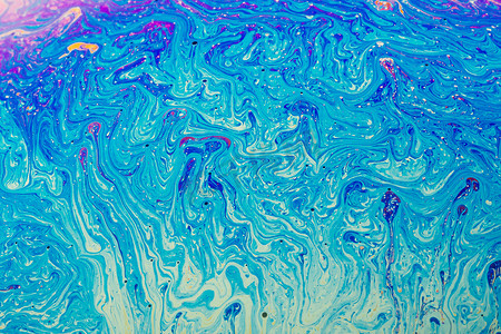 彩色流体背景摄影照片_由彩色肥皂泡膜制成的流体艺术。