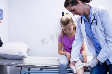 医生把绷带放在病人受伤的腿上