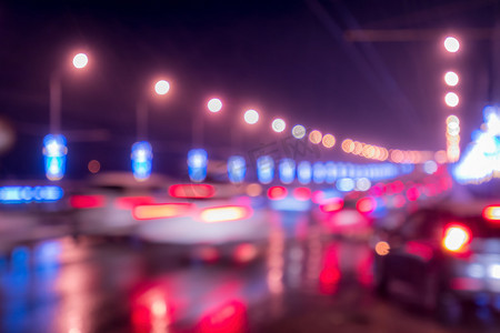 老年人起夜摄影照片_移动的汽车和灯笼的模糊灯光反射在夜城潮湿的沥青上。
