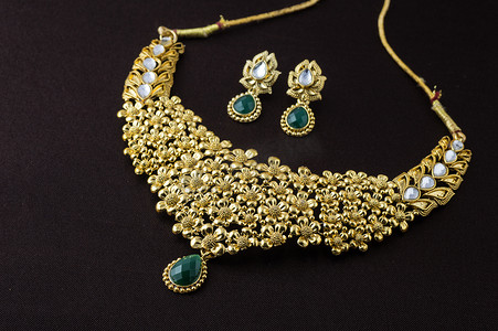 珠宝设计中摄影照片_印度传统珠宝，深色背景中吊坠和耳环的特写