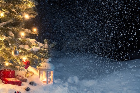 灯笼文字摄影照片_圣诞作文 — 圣诞树下雪地里的礼物和灯笼，装饰着灯光和圣诞树装饰，复制空间，文字位置