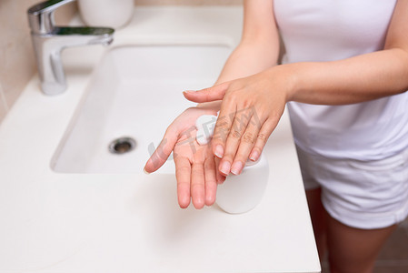 一个女人用肥皂水洗手。