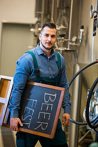 工厂标语牌摄影照片_拿着标语牌的啤酒肖像