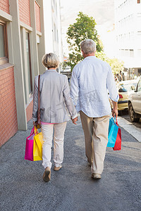 老年人走路摄影照片_幸福的成年夫妇带着他们购物的东西走路