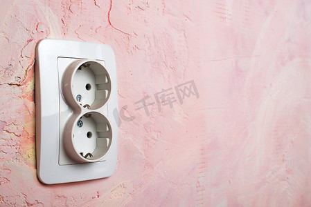 粉色墙上的白色插座