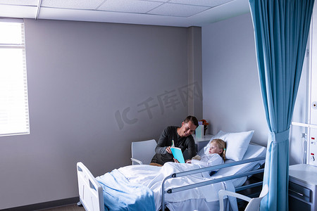 看病床摄影照片_在医院病床上看书的女孩和她的父亲