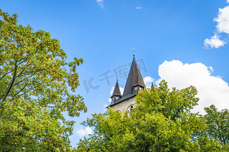 童话城堡摄影照片_耸立在绿树后的童话城堡塔