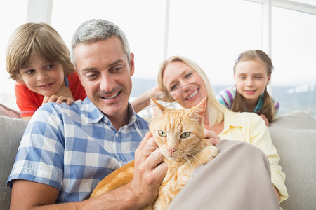 一家人和猫坐在家里的沙发上