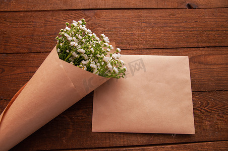 用工艺纸制成的信封，旁边是一束甘菊花