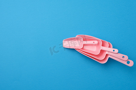 小清新产品展示摄影照片_蓝色背景中用于散装产品的一组粉红色塑料厨房勺