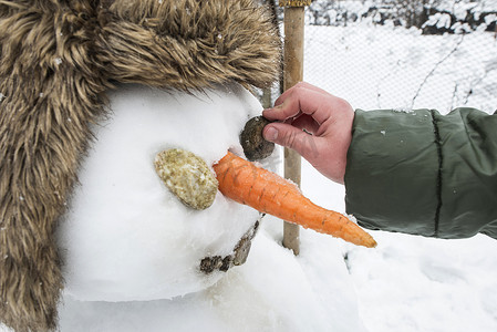 胡萝卜鼻子摄影照片_院子里的雪人