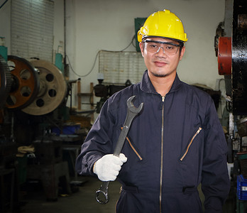 亚洲男性工人 在戴眼镜、安全帽和安全制服的行业 扳手工具架