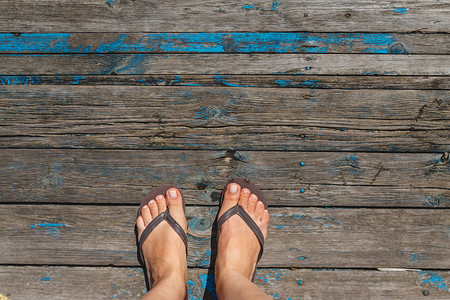 顶视图，女性腿的照片在木 o 上的沙滩拖鞋