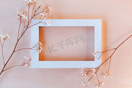 珊瑚纹理背景上的白色木框，上面有小花 — 贺卡或邀请函的模板