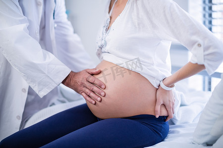 孕妇摄影照片_医生在病房里摸孕妇肚子的中段
