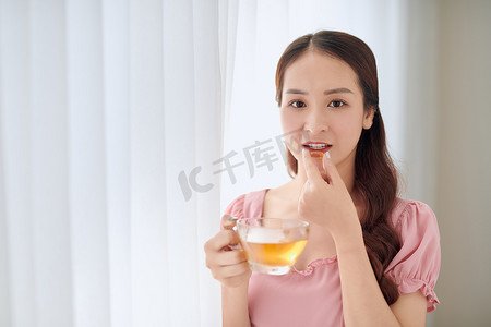 年轻漂亮的亚洲女人吃药喝水
