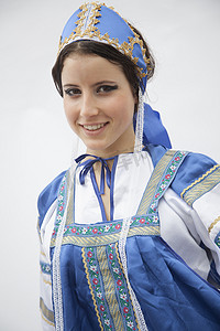身着俄罗斯传统服装的年轻微笑女性肖像，摄影棚拍摄