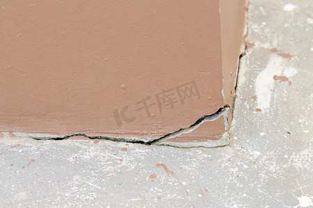 混凝土外墙旧棕色墙壁的深裂缝和孔洞损坏移动或开裂混凝土。