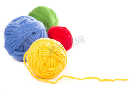 白色背景上的蓝色、红色和黄色羊毛线球