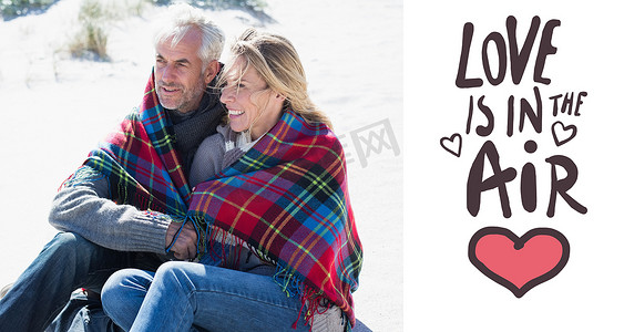 合成类ppt模板摄影照片_坐在沙滩上裹着毯子的幸福夫妻的合成图像