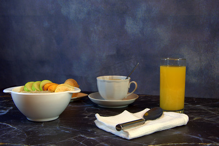 适当的早餐，一盘水果片燕麦片，一杯橙汁，一杯咖啡和两个羊角面包。