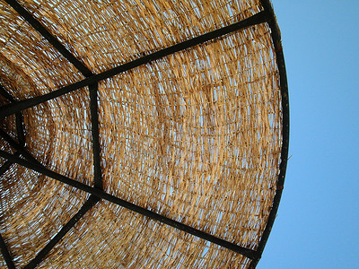 太阳伞摄影照片_在蓝天背景的柳条太阳伞。