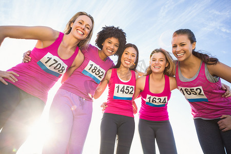 五位微笑的跑步者支持乳腺癌马拉松