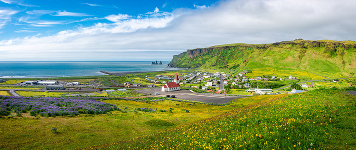 夏季，冰岛南部的玄武岩堆 Reynisdrangar、黑沙滩、教堂和 Vik 市全景
