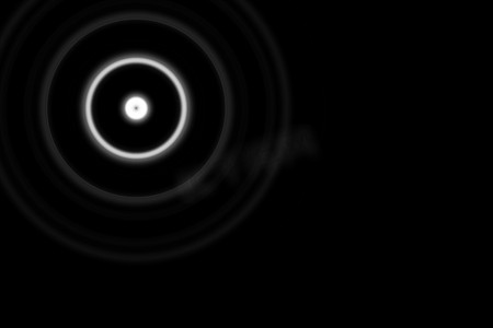 白色光晕摄影照片_黑色背景上带环形灯的抽象白色圆圈